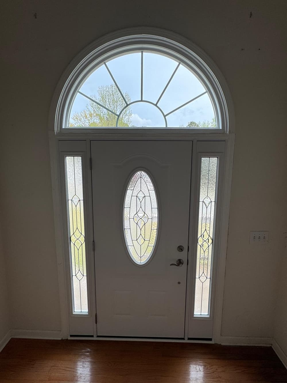 New entry door with leaded oval glass and sidelites, seen from the foyer